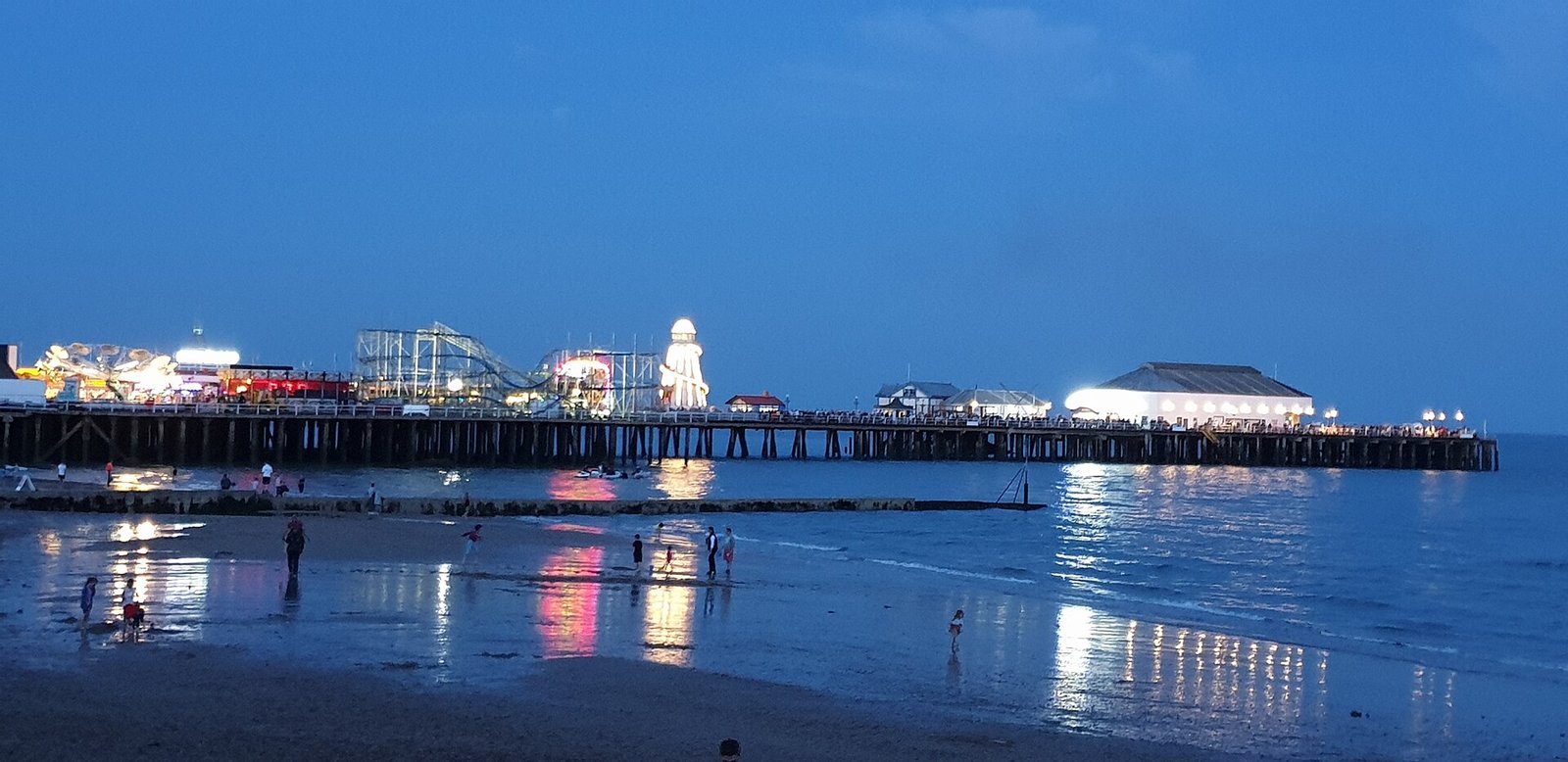Clacton Pier glowing across the water in the evening
